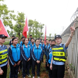 武汉铁路公安局天河机场车站派出所民警梁凝(右一)为学生志愿者们讲解铁路护栏检查知识。