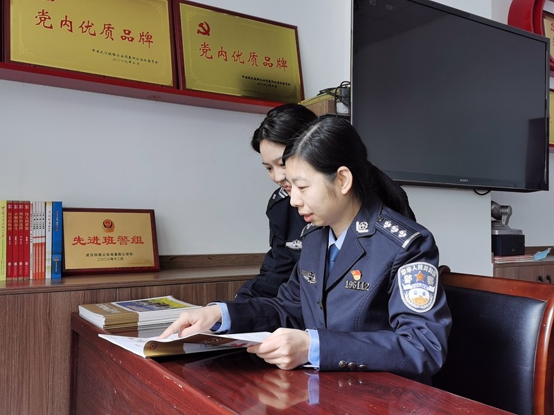 蒋辉（右）与辅警正在阅读新收到的《铁道护路联防》期刊_副本.jpg