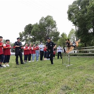 2021年5月31日，湖北省武汉市，武汉铁路公安处警犬大队训导员为志愿者学生们进行警犬日常障碍训练演示，胡金力摄